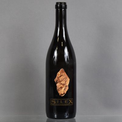 une bouteille de vin posée sur une table à côté d'un verre