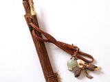 un petit bâton en bois muni d'un manche et orné de quelques breloques