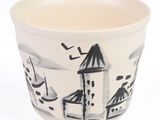 a white cup with a black and white design on it