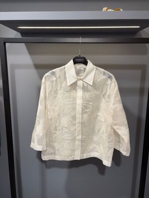 une chemise blanche suspendue à un cintre devant un mur
