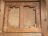 a person holding up a wooden frame with a picture inside of it
