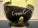 a black and yellow vase with a picture of a man on it