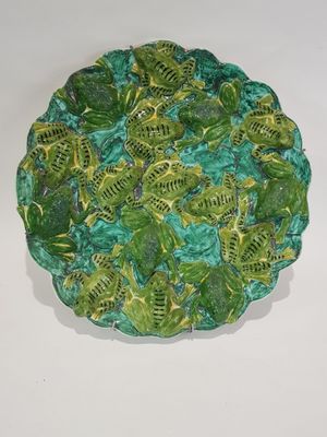 a green plate with a lot of green leaves on it