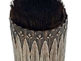 a pot with a brush inside of it on a white surface