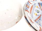 a white bowl with a blue and red design on it and a white bowl with a red and blue design on it