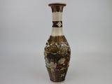 a brown and white vase sitting on a white surface