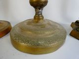 a gold plate with a candle on top of it