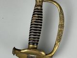 an old sword with a gold handle on a white surface