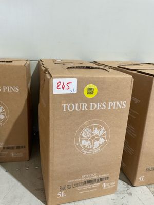 trois cartons de vin posés par terre dans une pièce