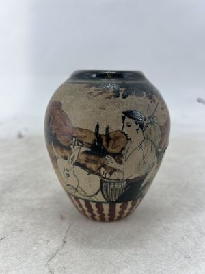 un petit vase avec un tableau posé sur une table