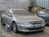 a silver car parked in a garage next to other cars