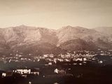 a black and white photo of a town with mountains in the background
