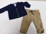 a baby boy ' s outfit and pants on a table