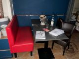 a table with two red chairs next to a blue wall