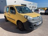 La petite camionnette jaune est garée devant un immeuble.