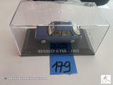 une petite voiture bleue dans une vitrine transparente posée sur une table