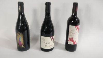 three bottles of wine are lined up on a white surface