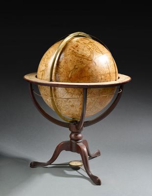 un vieux globe terrestre posé sur un socle, sur fond noir