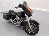 une moto noire et orange garée dans une pièce blanche