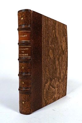 an old book with a leather cover sitting on top of a white surface