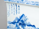 a blue and white vase with a mountain scene on it