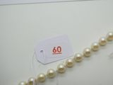 une photo d'un collier de perles blanches sur lequel figure une étiquette de prix
