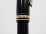 a close up of a fountain pen with a black body and gold trim