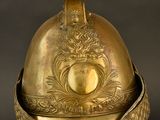 an antique helmet on a stand on a black background