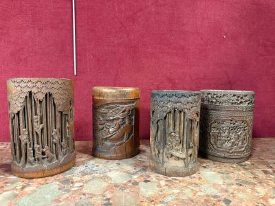 plusieurs types de vases sculptés posés sur une table, sur fond rouge
