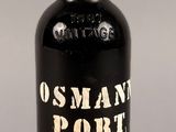 une vieille bouteille noire avec une inscription blanche, posée sur une table