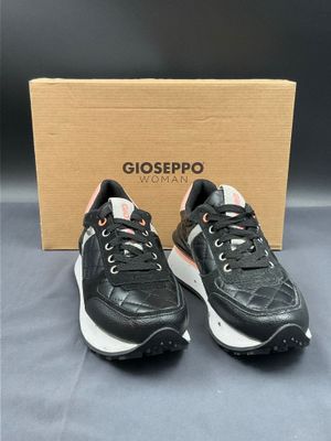 a pair of black and white sneakers in front of a box