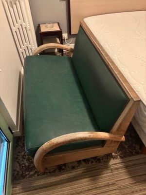 une chaise verte près d'un lit dans une chambre