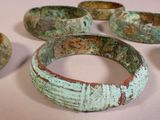 several pieces of green and brown bracelets sitting on a table