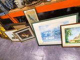 de nombreux tableaux encadrés posés sur une étagère dans une pièce