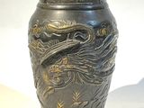 un vase orné d'un dragon posé sur une table