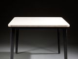 a white table with black legs and a white table top