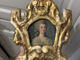 a gold frame with a picture of a woman in it
