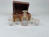 four glasses and a bottle sitting next to a wooden box