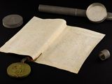 an open book with a wax seal on it next to some other items