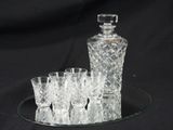 a glass tray with a glass decanter and four glasses on it