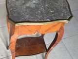 une petite table avec un plateau en marbre sur un sol carrelé