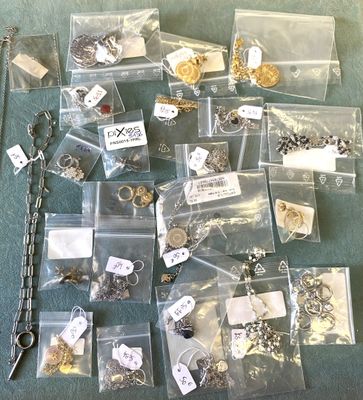 de nombreux types de bijoux, rangés dans des sacs posés par terre