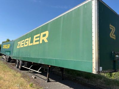 un semi-remorque vert garé sur le bord de la route