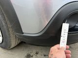 a person holding a ruler in front of a car