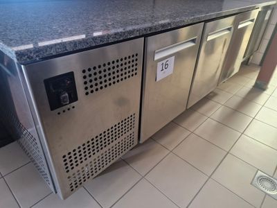 a stainless steel refrigerator in the middle of a tiled floor