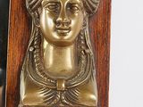 a clock with a gold face on it and a mirror behind it