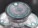a stack of tins of hemp powder sitting on a table