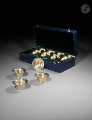 une photo montrant une boîte contenant des tasses et des bols en laiton posée sur une table
