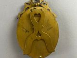 an image of a gold medal with a woman ' s face on it