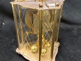 a gold clock inside of a glass case on a black background